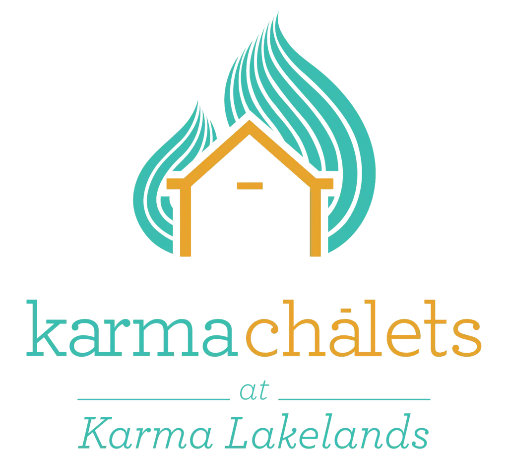 Logo of Karma Chalets at Karma Lakelands with stylized house and leaf design.
