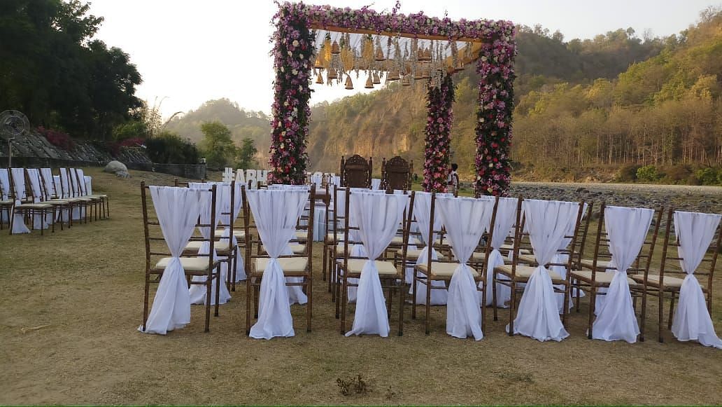  An image of a outdoor banquet hall with chairs and a stage decorated for destination wedding halls - Riverview Retreat, Corbett