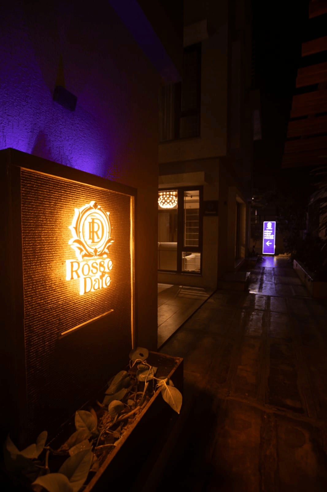 The illuminated Rosse Dale entrance signage lighting the arrival pathway at night at Rossedale Suites & Hotel in Peelamedu, Coimbatore