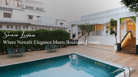 Elegant outdoor area with swimming pool, staircase to veranda, white walls and greenery, with text Signature Location Where Nawabi Elegance Meets Beauty.