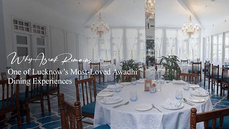 A promotional banner for Azrak at Saraca Hotel Lucknow featuring an elegant dining room with chandeliers, round tables and heritage-inspired interiors.