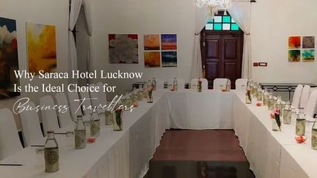 Elegant banquet hall setup with white chairs and tables under warm lighting.