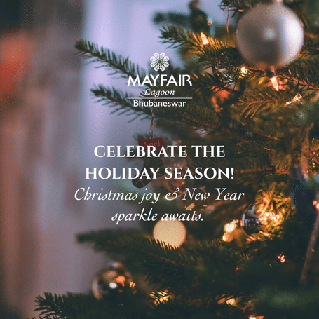 A creative which says celebrate the holiday season - Christmas Joy and New Year Sparkle awaits at MAYFAIR Lagoon, Bhubaneswar. It features a pine tree decorated with lights and Christmas balls.