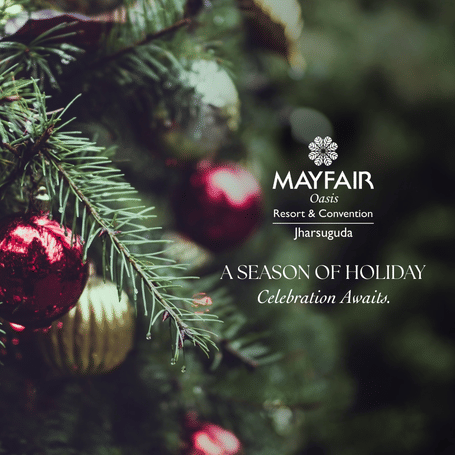A  creative banner which says a season of joyous Christmas awaits at MAYFAIR Oasis Resort and Convention, Jharsuguda. It also features a pine tree decorated for Christmas.