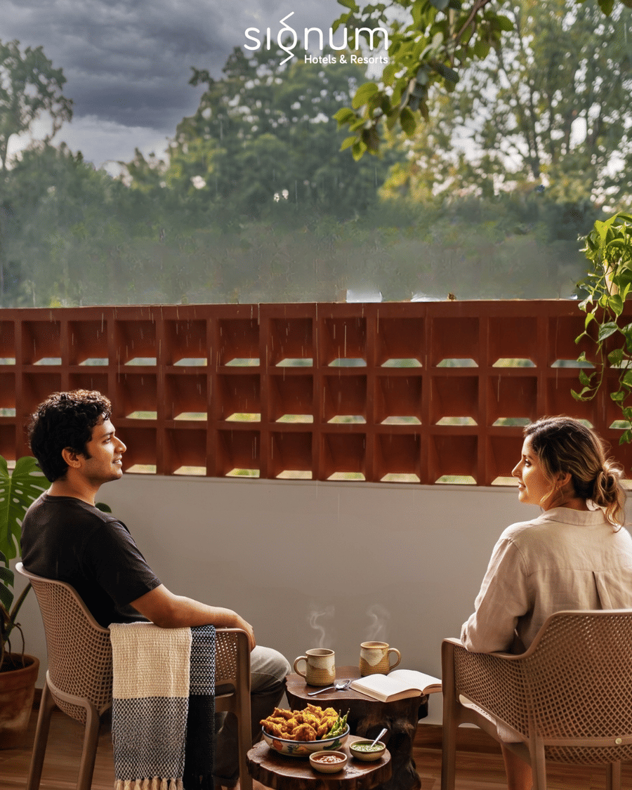 Two guests with evening chai on a terrace looking out over the monsoon forest
