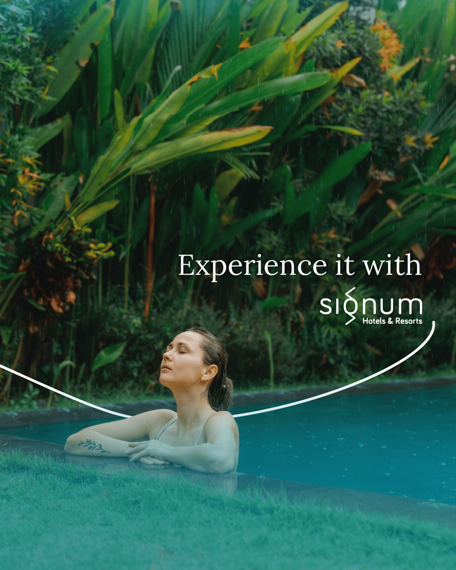 A guest relaxing at the edge of the resort pool surrounded by tropical planting
