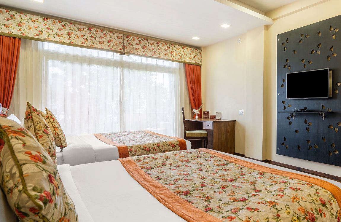 Family room at Summit Barsana Resort & Spa, Kalimpong with a double bed and a television