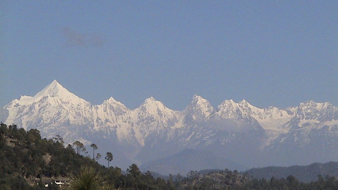 Panoramic view of a mountain range with a clear blue sky.