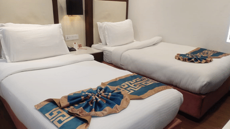 A close-up shot of 2 single beds with soft pillows kept against the headboard of the bed at  Lords Inn Jodhpur.