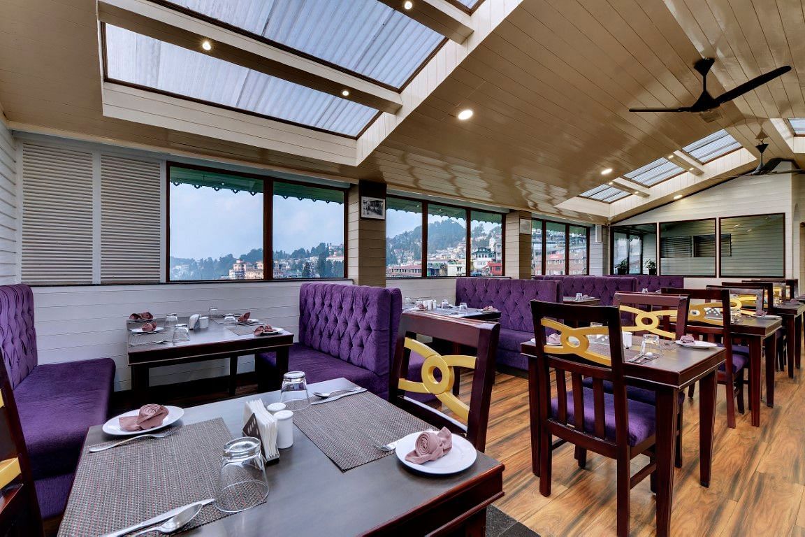 An image of a restaurant with seating arrangement and minimal decoration - Sumitel Darjeeling