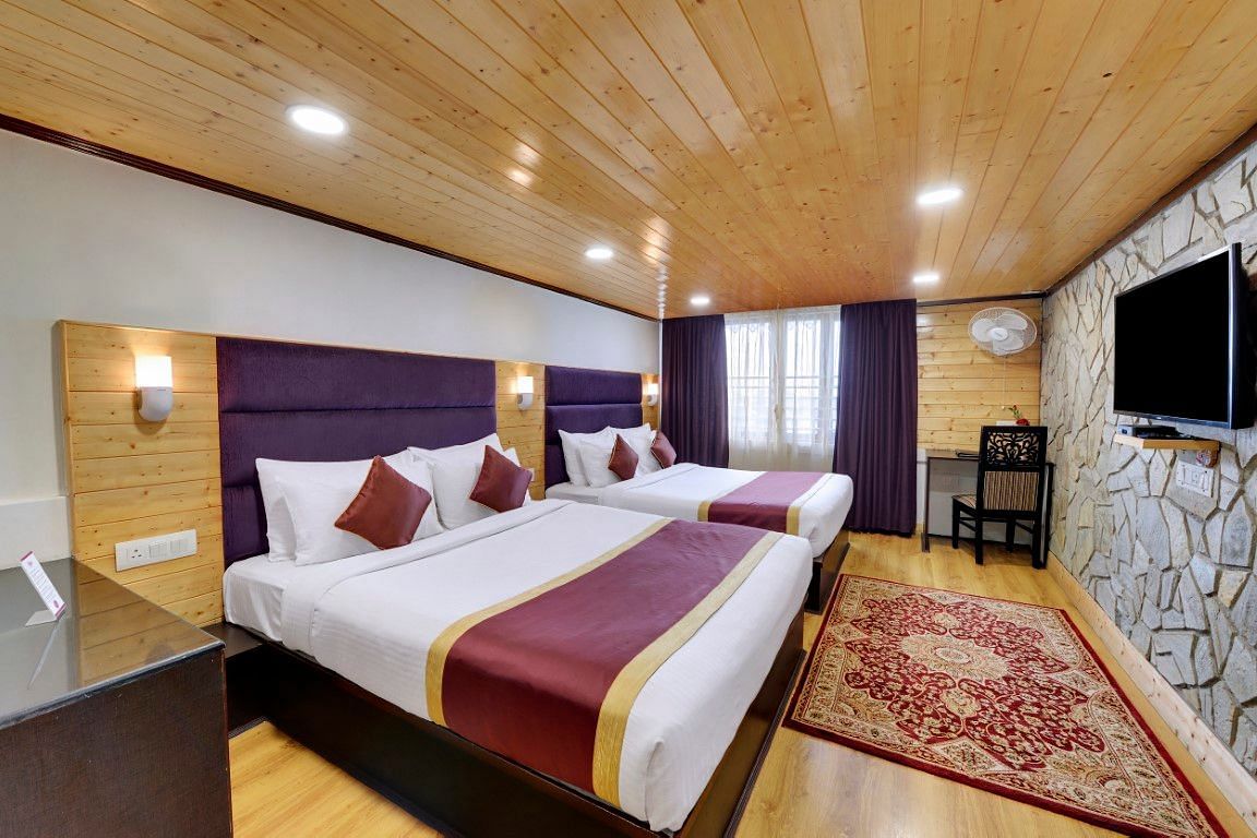 An image of a room with twin bed, flat screen TV, decorative lighting - Sumitel Darjeeling