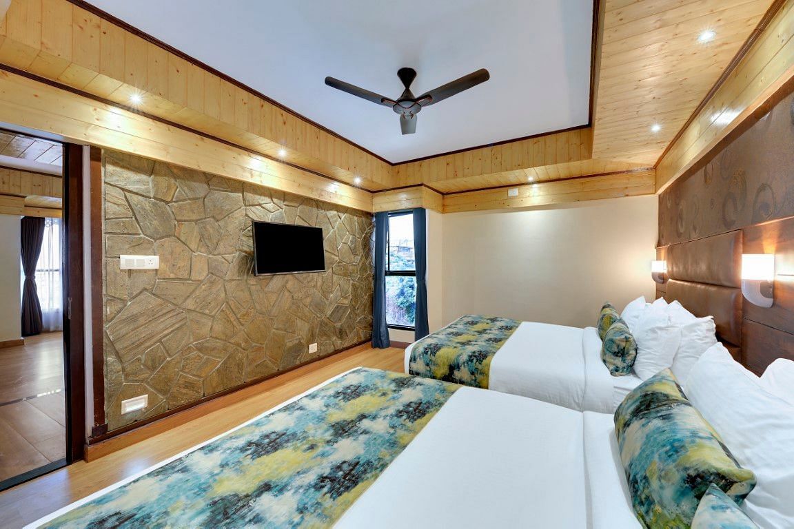 An image of Sumitel Queensyard premium room with king size bed, tv, ceiling fan, and minimal decoration