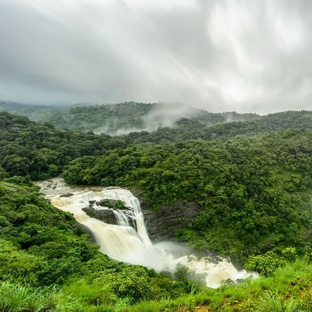 Mallalli Falls, Coorg, amidst misty mountains.