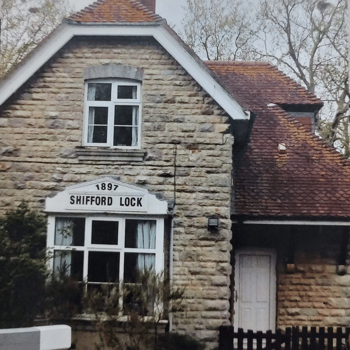 Front view of a stone cottage with a red tiled roof