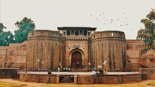 An ancient monument with birds, trees, and sky in the backdrop.