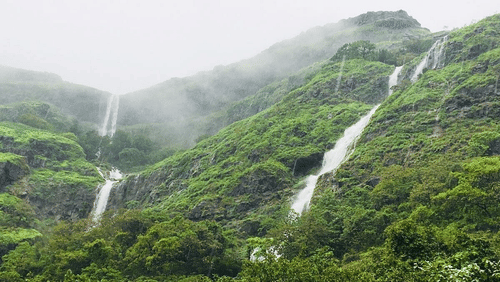 Falls amidst mountains covered with fog.