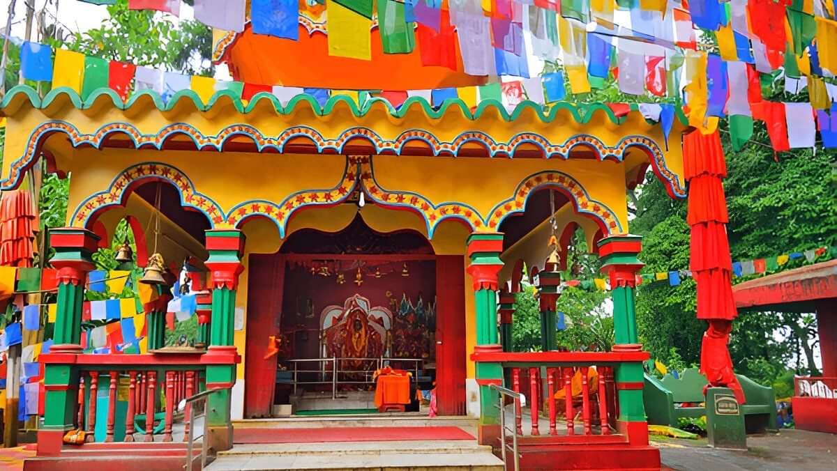Brightly painted mahakal temple adorned with prayer flags, showcasing rich Himalayan culture.