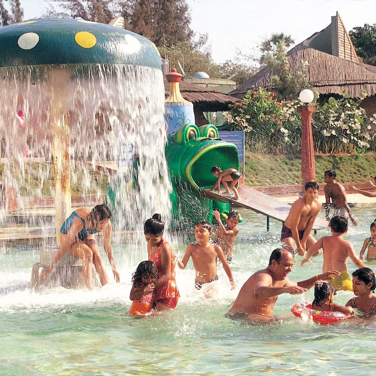 Kids with adults enjoying Frog Slide at Water Kingdom in the water