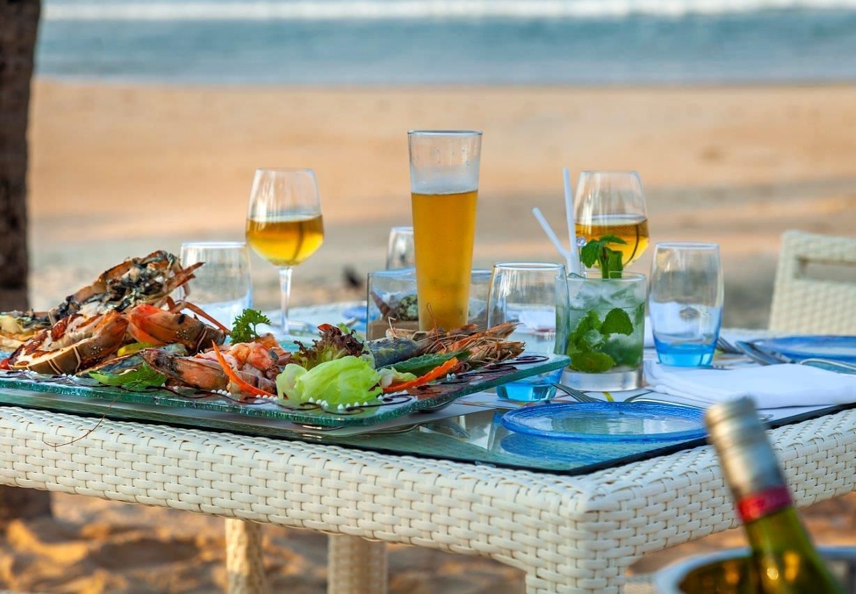 a close up shot of a table with many food items and beverages - Caravela Beach Resort Goa