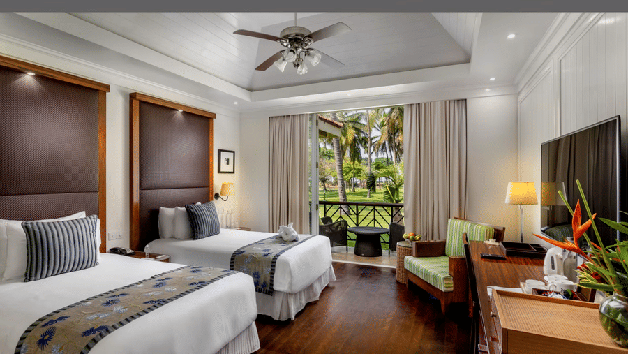 two single beds next to each other in front of the tv inside the Presidential Villa - Caravela Beach Resort Goa
