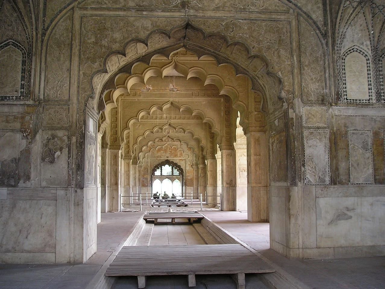 Arched hallway of a historic Mughal-style palace in India.