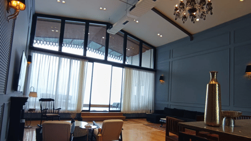 Suite with large windows, plush furnishings, and a writing desk - Polo Cherrapunjee Resort