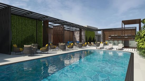 An outdoor swimming pool with lounge chairs at Riviera Sarovar Portico, Pathankot.
