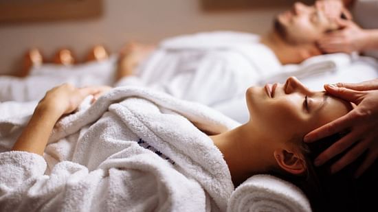 A peaceful scene in a spa with a person receiving a relaxing head massage, highlighting a serene wellness experience.