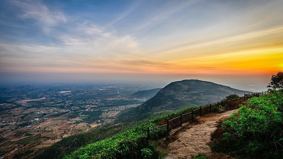 Breathtaking sunrise view from Nandi Hills with orange skies and silhouetted hilltops.