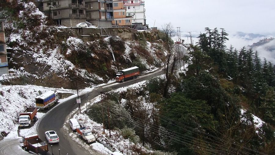 The aerial view of a busy road on the side of a snowy mountain  - The Orchid Hotel Shimla