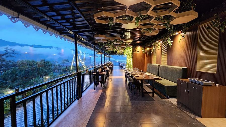 An outdoor dining area with a roof, offering scenic mountain views | Voyage The Royal Retreat, Gangtok