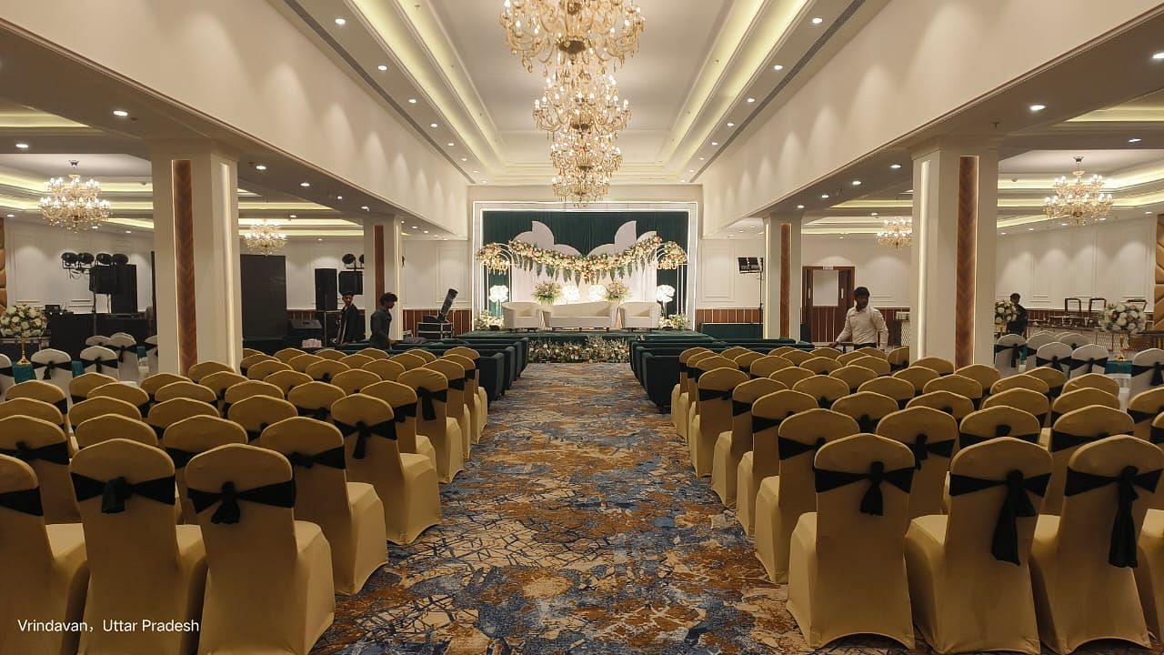 Brij Eternity, Vrindava |  A banquet hall featuring a grand chandelier, plush seating, and a sophisticated ambiance for events.