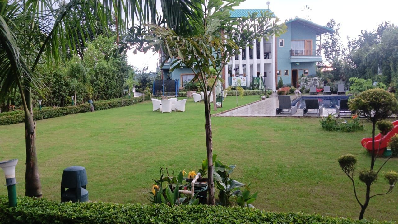 The Lawn 1 at Corbett Nirvana Resort featuring trees surrounding it.