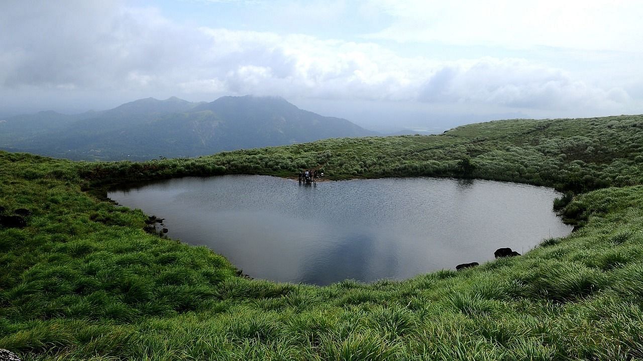 A scenic hilltop lake with misty mountains in the background.