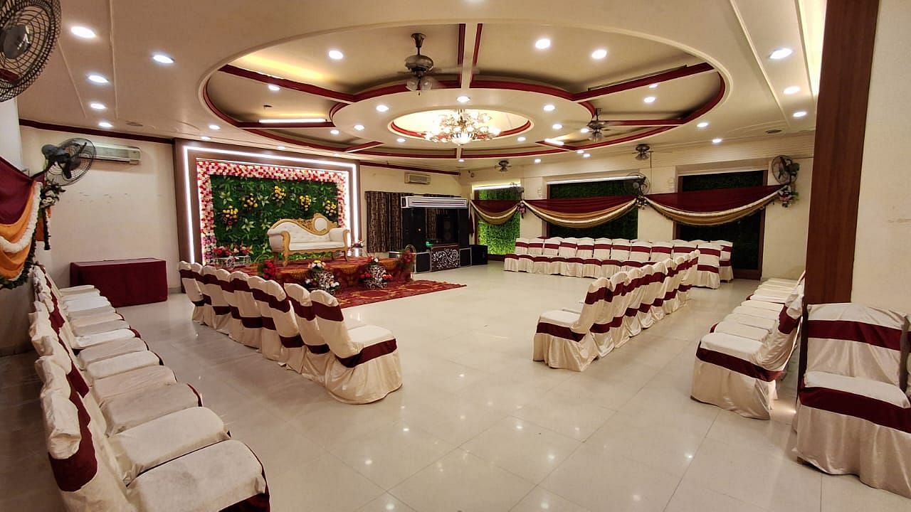 An image of a party hall near IIT Roorkee, adorned with a beautiful chandelier, elegant decor, and neatly arranged chairs - Motel Divine International, Roorkee
