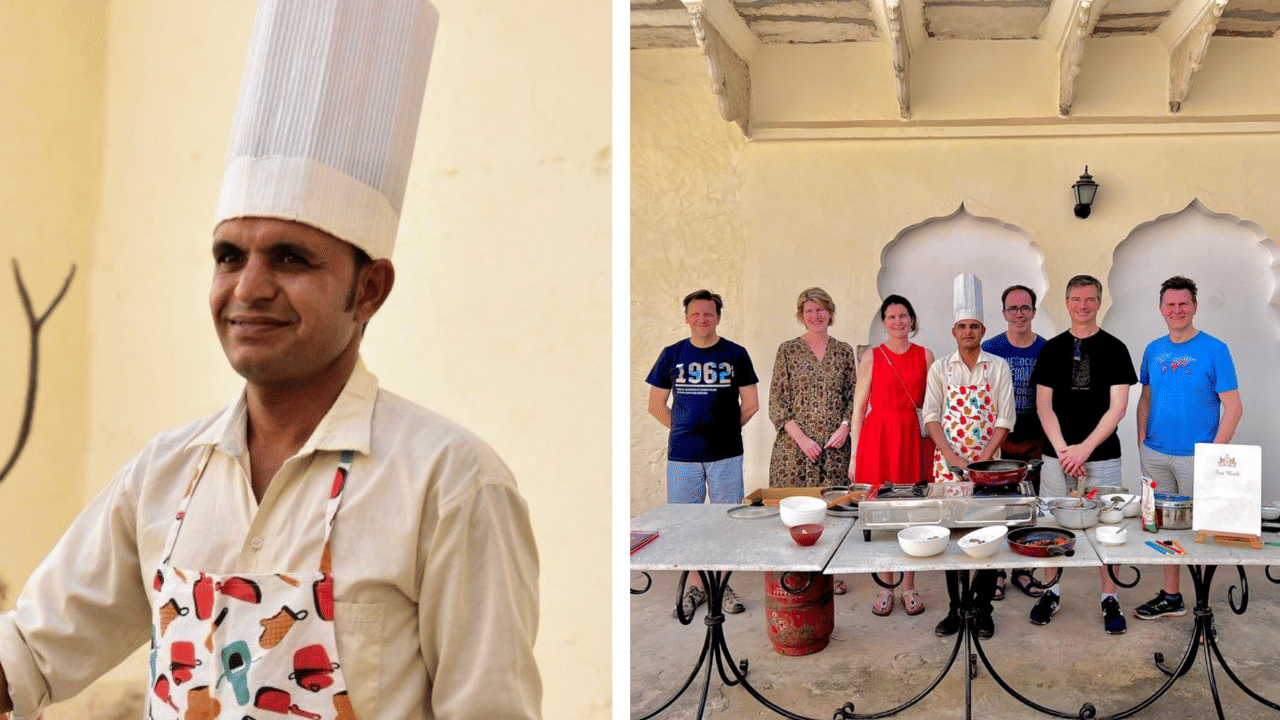 Chef Ranjit Mali in a tall white hat and printed apron standing in a courtyard, alongside a small group of guests posing behind a cooking station