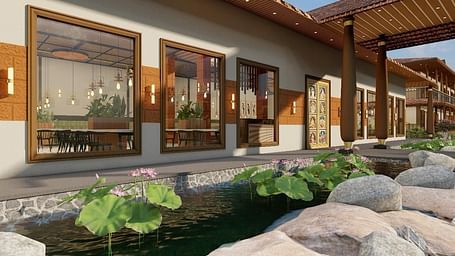 Exterior view of a resort building with a pond and rock landscaping - Ayana Resorts, Hyderabad.