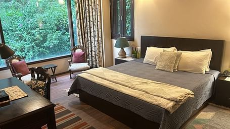 A large bed next to a nightstand in one of the bedrooms in 2BHK at SOUTHGATE KASAULI BY ZENQ.
