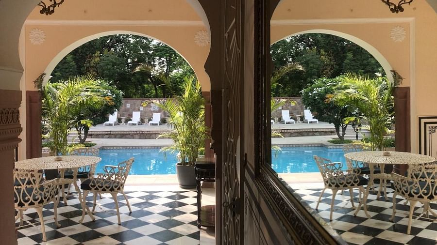 A beautiful poolside view framed by arched pillars and checkerboard flooring - Khas Bagh ,Jaipur.