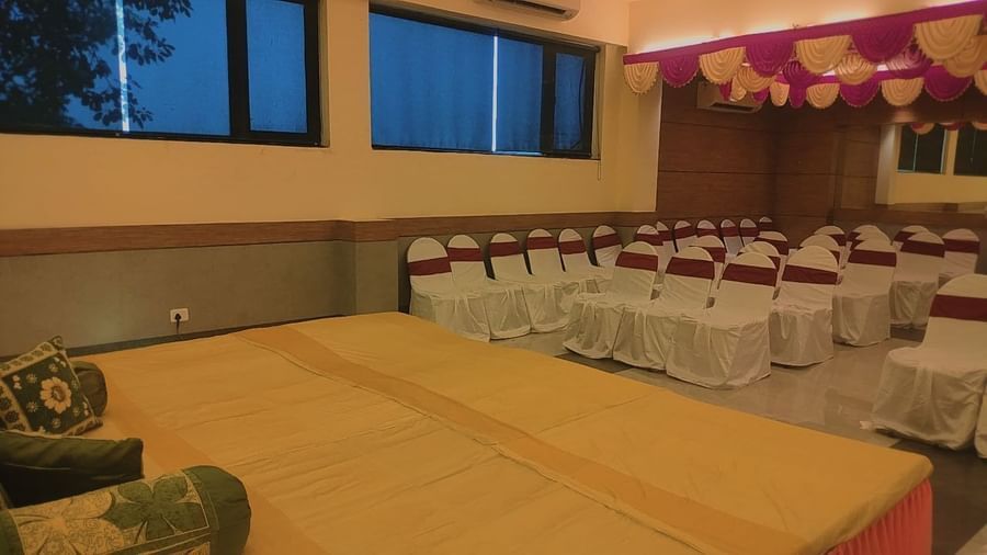 Event hall with low seating stage and chairs arranged in rows at Max Hotel Prayagraj.