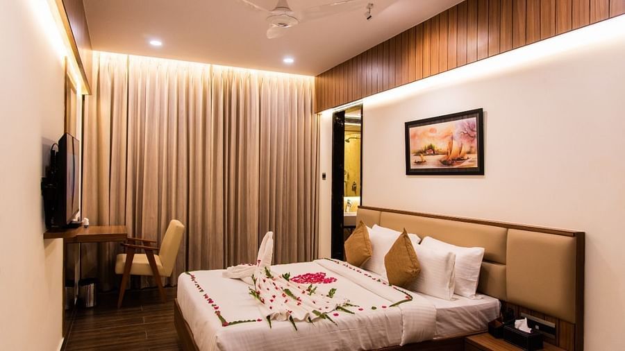 Room with plush bed decked with table and chair at TGI Felicity