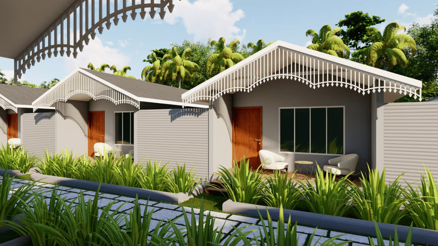 A view of two small grey houses with curved roofs, set back from a walkway at Trishvam Palolem Beach Resort, Goa.