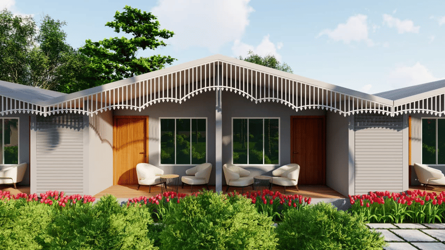 A low, modern house with a curving roof, surrounded by green bushes and a tidy lawn at Trishvam Palolem Beach Resort, Goa.