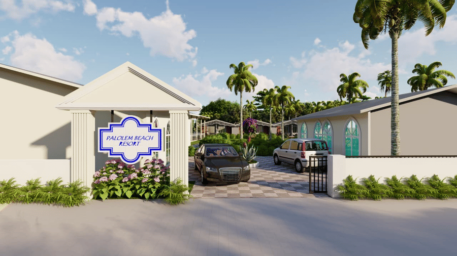 The entrance to Trishvam Palolem Beach Resort, Goa's property featuring a white decorative wall and black car parked outside.