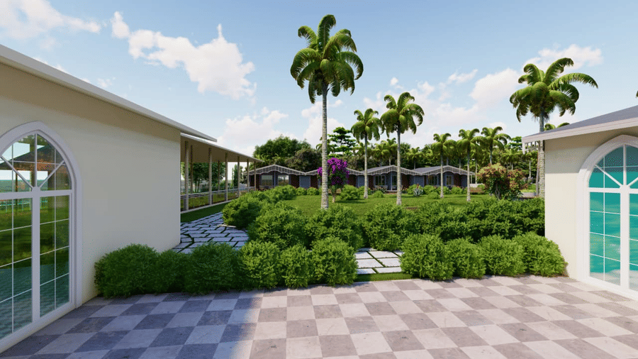 An outdoor tiled space with greenery at the background and the arched windows of the houses visible on both the sides at Trishvam Palolem Beach Resort, Goa.