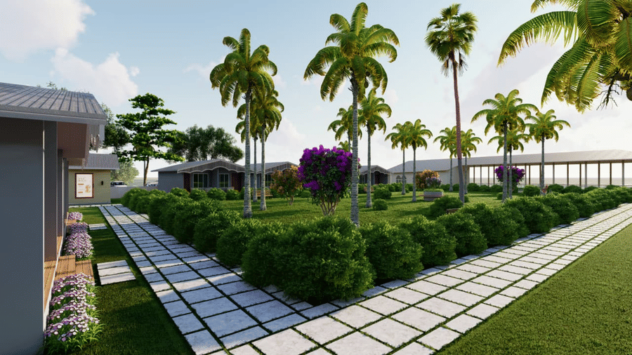 A garden area featuring a white walkway lined by low green hedges and several palm trees at Trishvam Palolem Beach Resort, Goa.