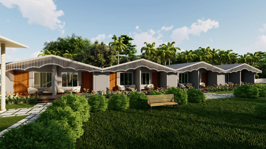 A row of small houses faces a lawn with a wooden swing set and several palm trees at the background at Trishvam Palolem Beach Resort, Goa.