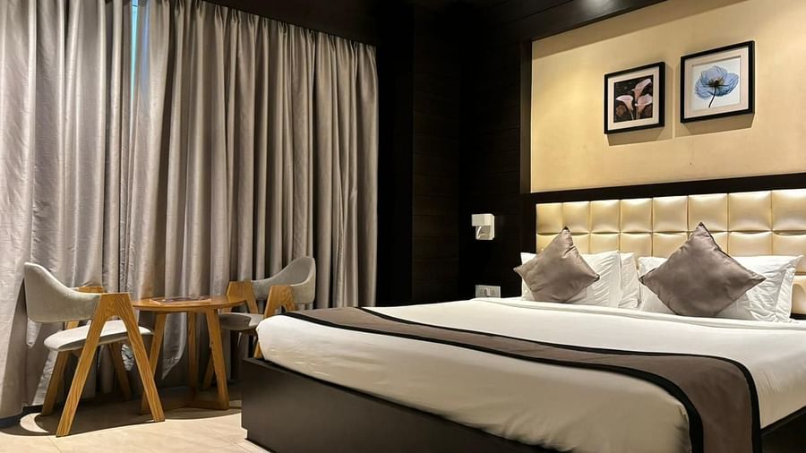 a view of king bed and a work desk of Premium Colony King bed room at Wonder country club resort