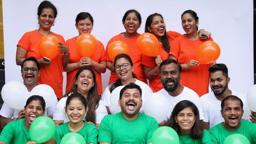 People sitting in three rows wearing tri colour clothes