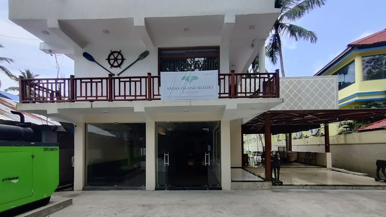 A shot of the entrance at the resort featuring a two storey building with a backdrop of clear sky  | Arina Island Resort